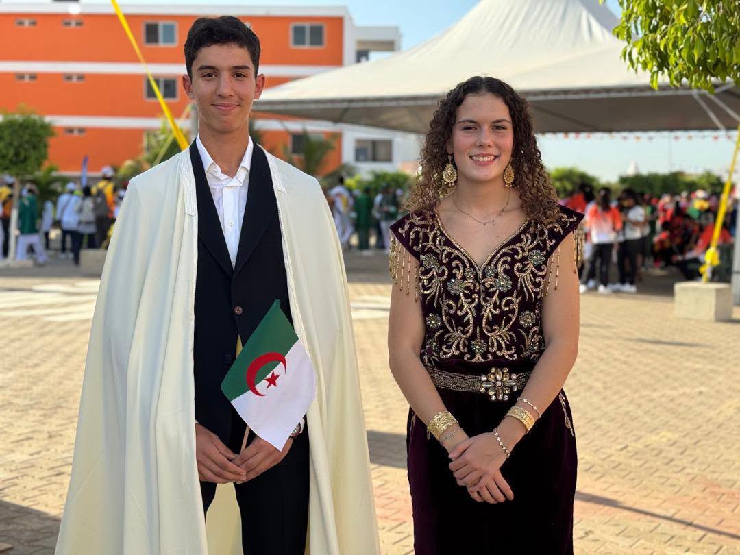 Tina Morris and Faraj Mohamed Younes raise the Algerian flag at the opening of the 2026 Dakar Youth Olympic Games.